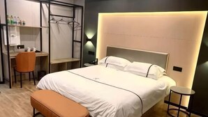 Une chambre d’hôtel moderne avec un grand lit, un bureau et une chaise.