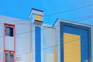 A building with a red door, a window, and a yellow and blue facade. - Reddoorz @ Guest Hotel Passi City Iloilo (Angeles City)
