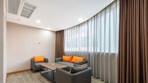 A modern hotel room with a curved ceiling, a sofa set, a small table, and a large window with curtains. - Jiada Hotel (Zhuhai Lovers Road Seaside Swimming Pool) (Zhuhai)