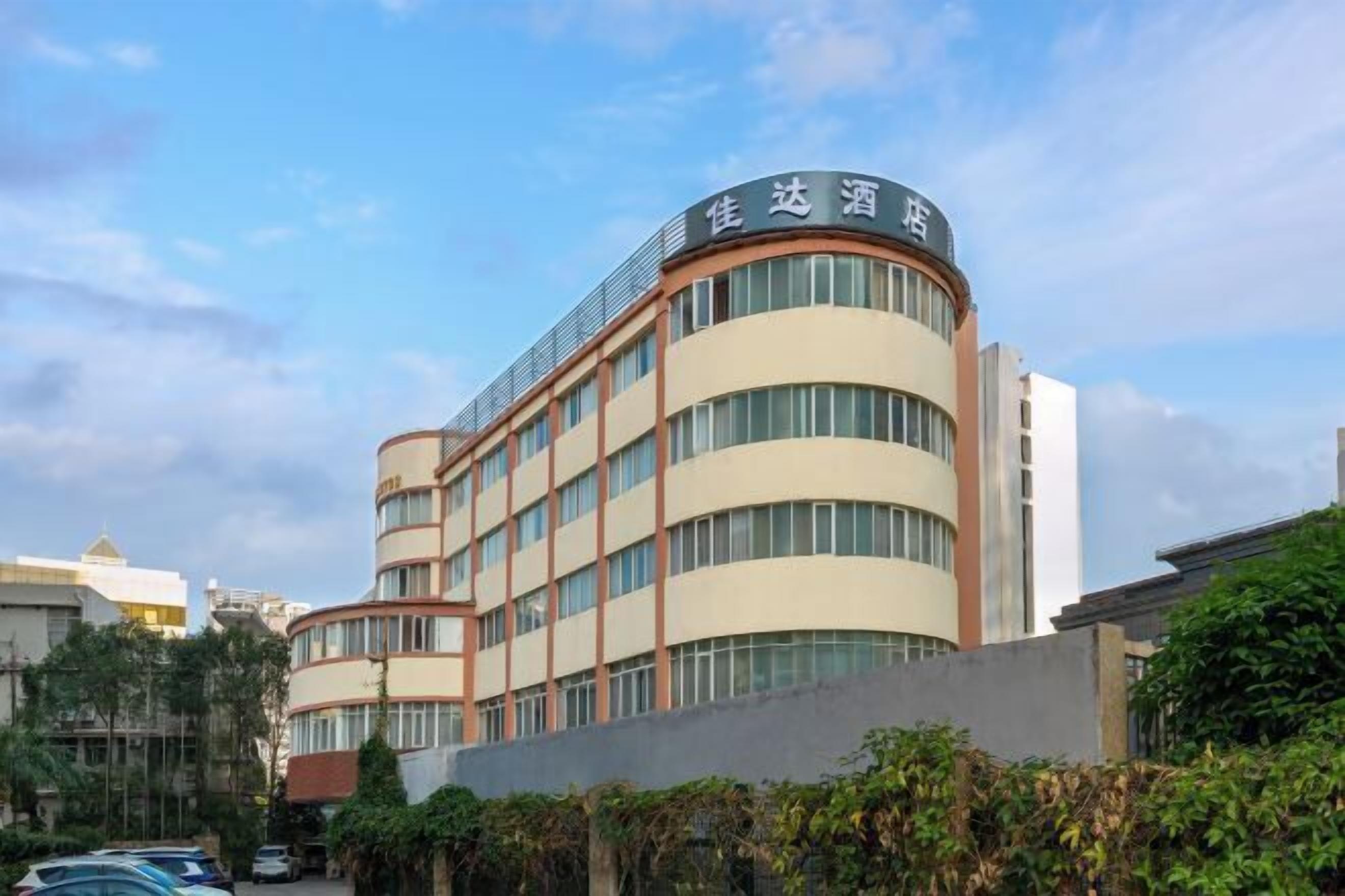 A multi-story hotel with a curved facade and a sign in a foreign language.