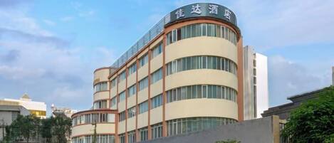 A multi-story hotel with a curved facade and a sign in a foreign language.