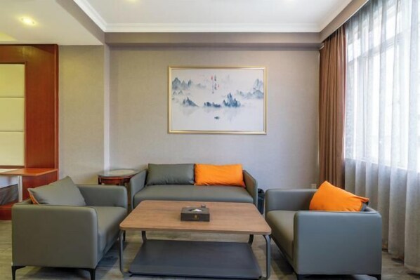 A modern living room with two sofas, a coffee table, and a framed artwork on the wall. - Jiada Hotel (Zhuhai Lovers Road Seaside Swimming Pool) (Zhuhai)