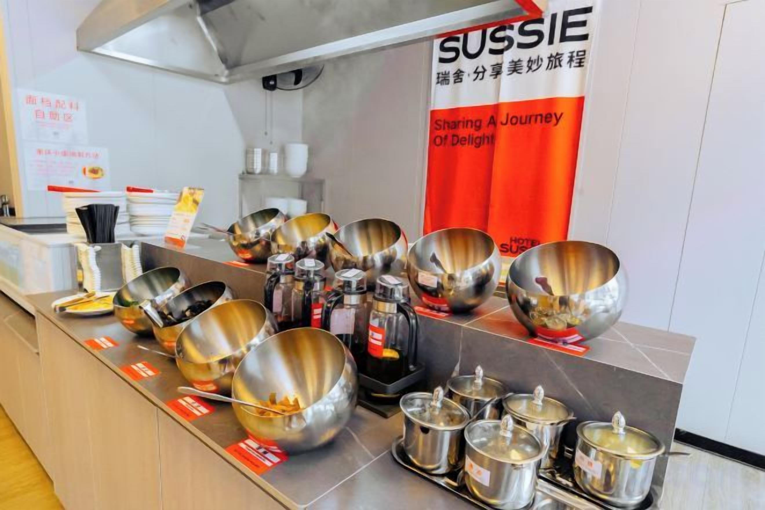 Una encimera de cocina con diverso utensilio de acero inoxidable y ollas.