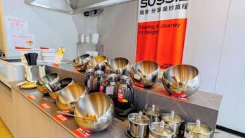 Una encimera de cocina con diverso utensilio de acero inoxidable y ollas.