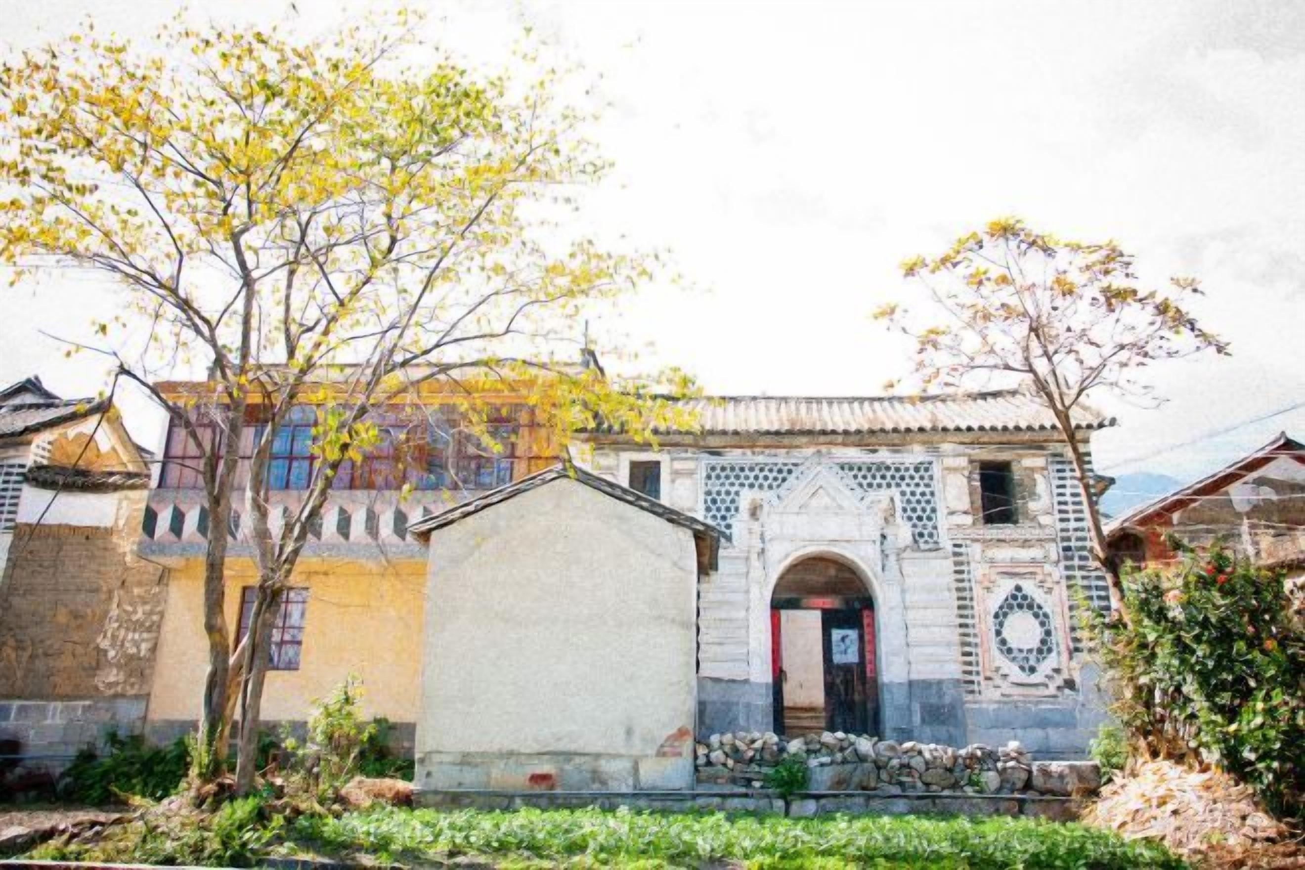 Un edificio tradicional con fachada de tejas, un arco central y una estructura adyacente más pequeña.
