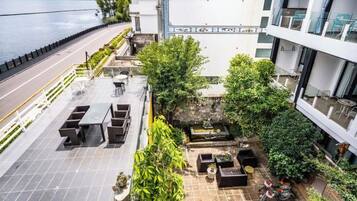 Terraza en la azotea con mobiliario exterior, vistas al agua y una bicicleta estacionada cerca.