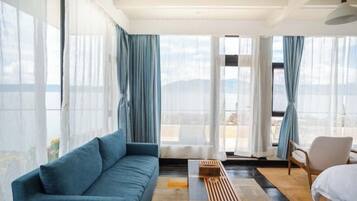 Una habitación de hotel moderna con sofá, una mesa de centro de madera, una silla y una cama.