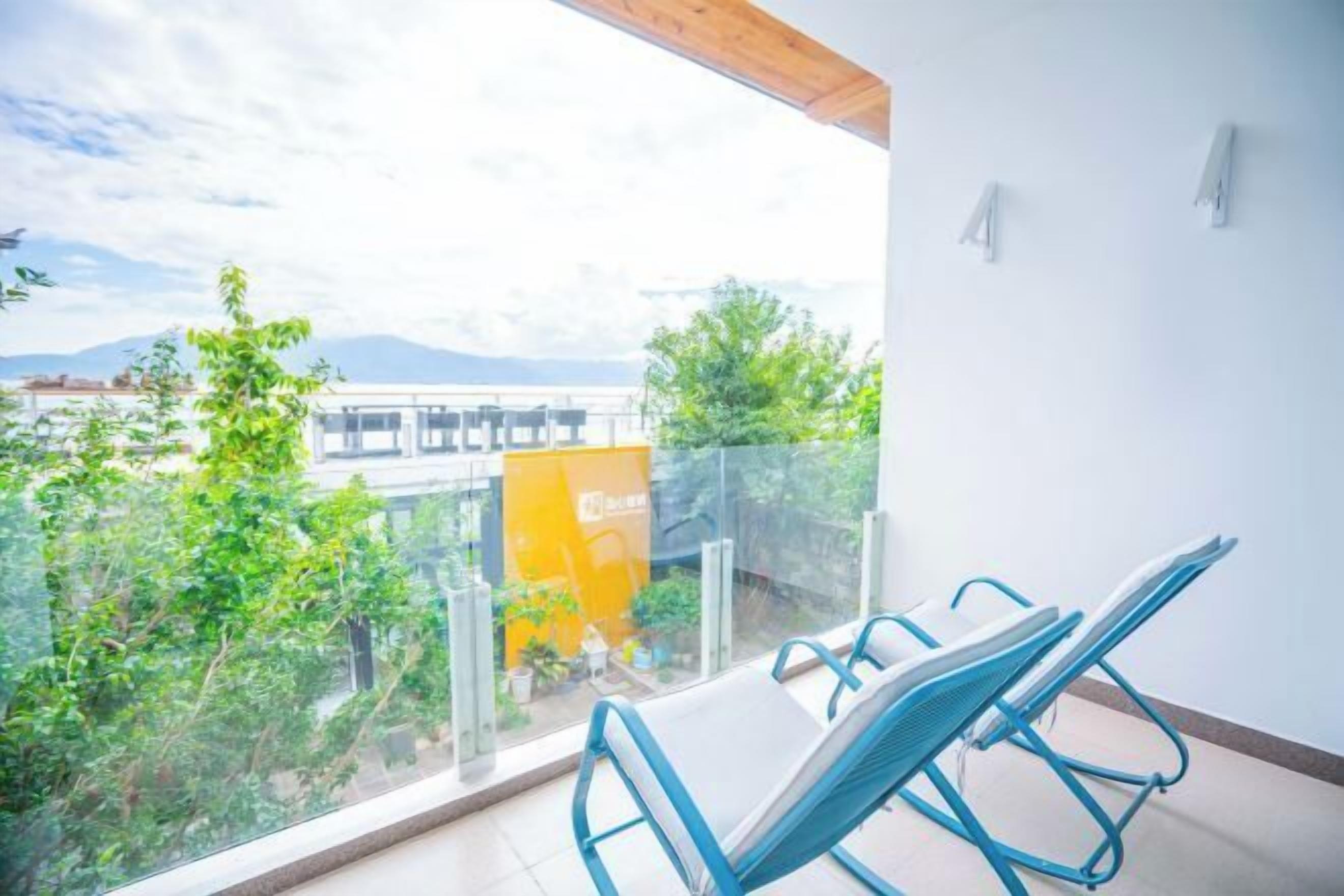 Ein Balkon mit Blick auf Grünflächen und ein Gebäude im Hintergrund.