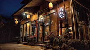 A wooden building with large glass windows and a sign in Chinese characters. - Lishui Zhugeshijia homestay (Lishui)