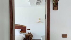 A bedroom with a wooden headboard, a white bed, a small wooden stool, and a white bathtub. - Lishui Zhugeshijia homestay (Lishui)