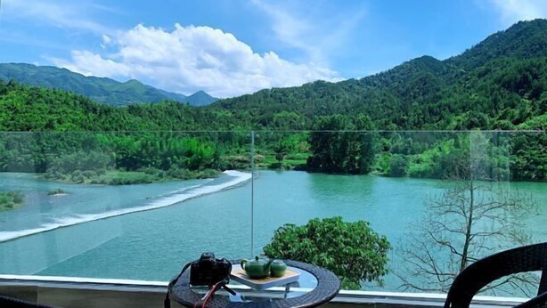 A balcony with a view of a river, mountains, and a clear sky. - Lishui Zhugeshijia homestay (Lishui)