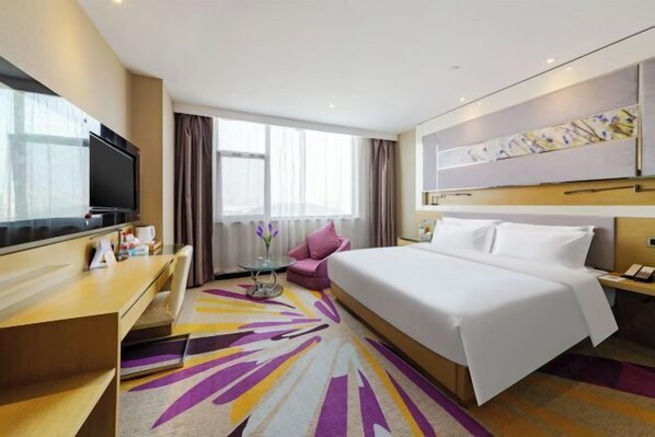 A hotel room with a large bed, a television, a desk, and a window with curtains. - Lavande Hotel Wuhan Wujiashan 5th Ring Sports Center (Wuhan)