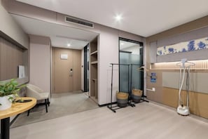 Une chambre d’hôtel avec un lit, une table de chevet, une lampe et une vue sur l’extérieur.