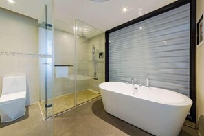 A modern bathroom with a freestanding bathtub, a glass shower enclosure, and a toilet. - Lavande Hotel Wuhan Wujiashan 5th Ring Sports Center (Wuhan)