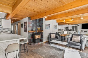 Cozy seating area with a central fireplace, comfortable sofa, and armchair, perfect for relaxing.