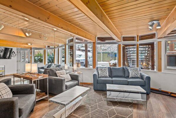 Relax in this spacious living area with a high ceiling, featuring a large sofa and coffee table.