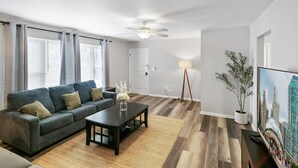 Ein modernes Wohnzimmer mit Sofa, Couchtisch und Stehlampe.
