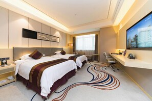 A hotel room with two beds, a desk, a chair, a TV, and a view of the city. - Rich Forex Hotel (Foshan)