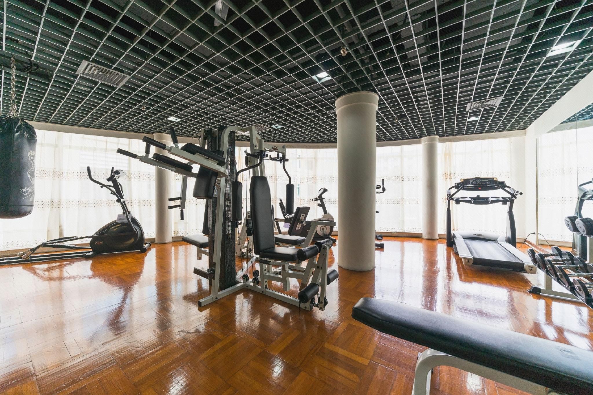 A gym with various exercise equipment, a punching bag, and a treadmill.