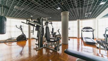 A gym with various exercise equipment, a punching bag, and a treadmill.