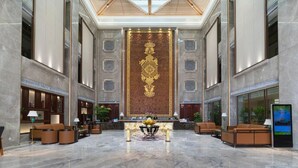 A spacious lobby with a marble floor, a reception desk, and seating arrangements. - Rich Forex Hotel (Foshan)