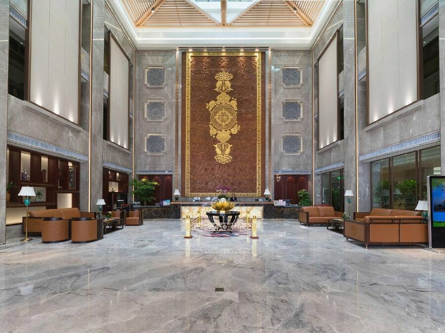 Un'ampia hall con pavimento in marmo, una reception e zone salotto.