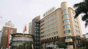 A multi-story hotel with a modern facade, multiple flags, and a fountain in the foreground. - Rich Forex Hotel (Foshan)