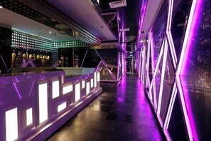 A modern interior with geometric lighting and a bar area. - Rich Forex Hotel (Foshan)