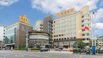 A hotel with a modern facade, multiple floors, and a prominent sign.
