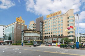 A hotel with a modern facade, multiple floors, and a prominent sign. - Rich Forex Hotel (Foshan)
