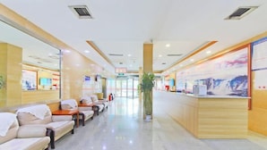 A hotel lobby with a reception desk, seating area with sofas, and a large plant. - Hebei Provincial State-owned Assets Supervision and Administration Commission (Shijiazhuang)