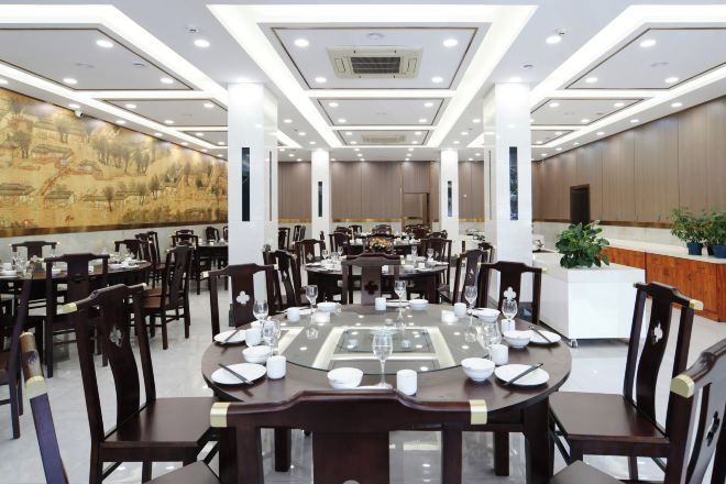 A conference room with round tables, chairs, and a large mural on the wall.