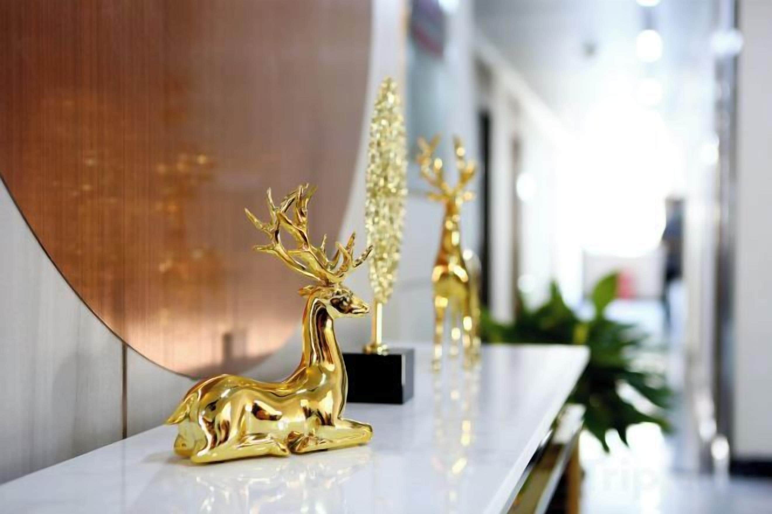 Een receptiebalie met een gouden hertenbeeldje en een plant op de achtergrond.