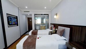 A hotel room with two beds, a TV mounted on the wall, a wooden floor, and a view through a glass door. - Hebei Provincial State-owned Assets Supervision and Administration Commission (Shijiazhuang)