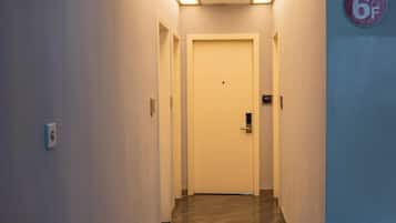 A narrow hallway with a door at the end, a light switch on the wall, and a 6F sign on the right.