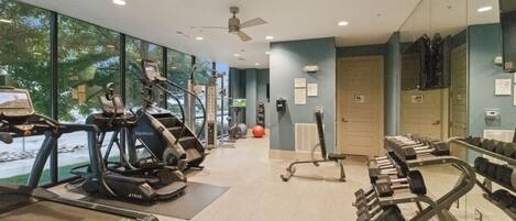 A gym with treadmills, elliptical machines, and free weights.