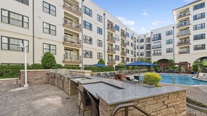 A rooftop bar with stone seating and a pool area in the background. - Kasa Village District Raleigh (Raleigh)