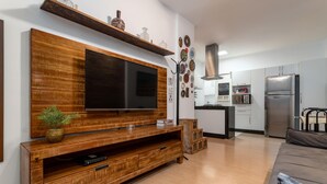 A modern living room with a wooden entertainment unit, a flat-screen TV, and a sofa. - 7 Minutes From Copacabana Beach Stc504 (Rio de Janeiro)