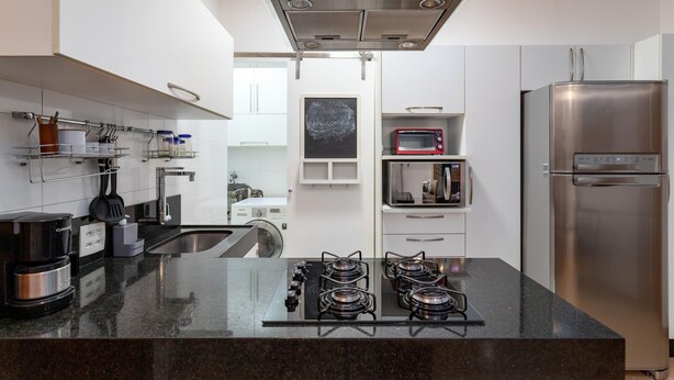 A modern kitchen with a gas stove, stainless steel appliances, and a glass backsplash. - 7 Minutes From Copacabana Beach Stc504 (Rio de Janeiro)