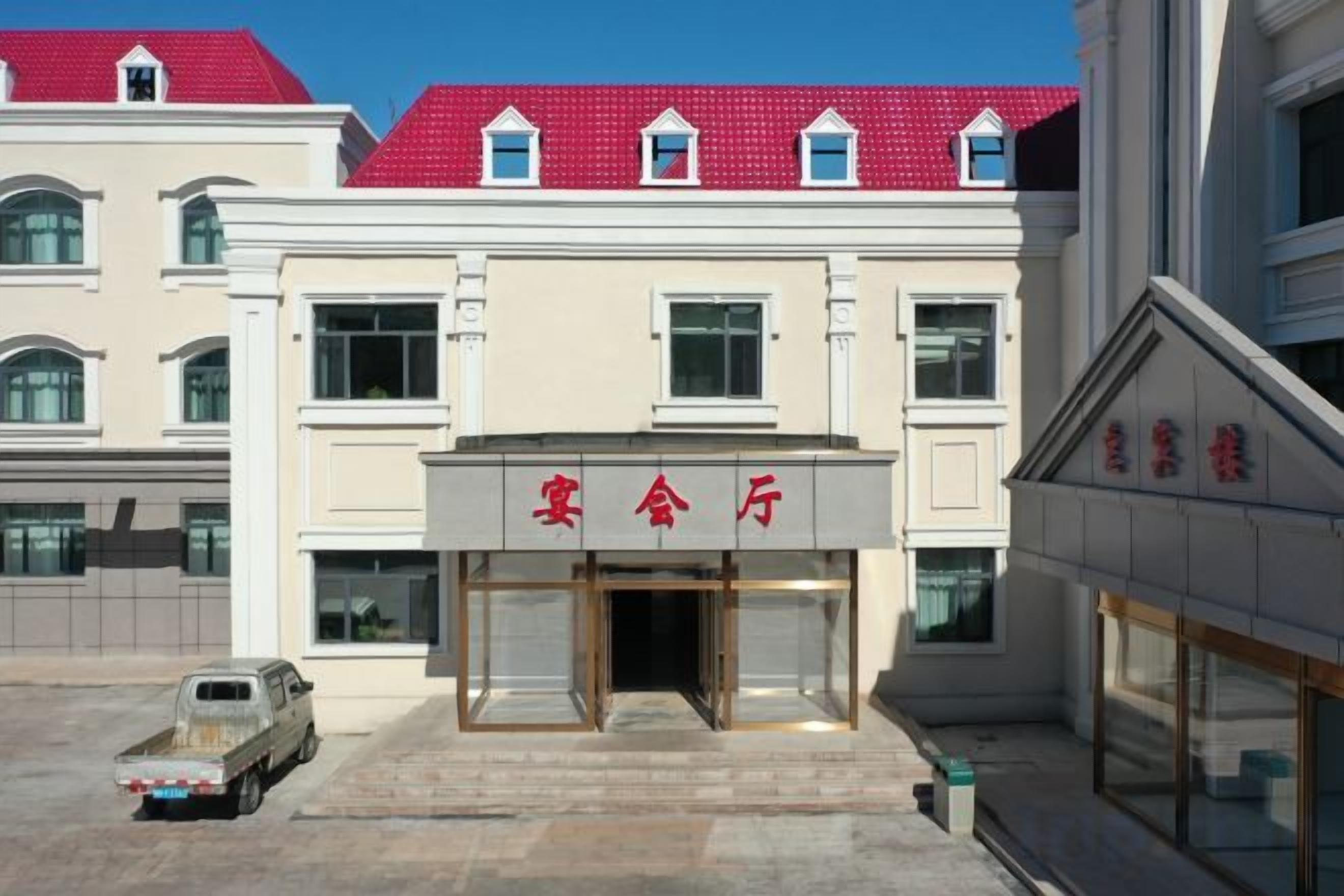 A building with a red roof and a sign that reads '客房' (hotel).