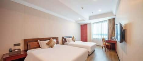 A hotel room with two beds, a desk, a chair, a TV, and a wardrobe.