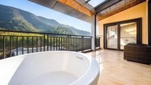 A modern balcony with a hot tub, wooden ceiling, and a mountain view. - Moganshan Liangshe Health Resort Hotel (Deqing)