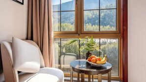 A room with a view of mountains, a round table with fruit, and a white chair. - Moganshan Liangshe Health Resort Hotel (Deqing)