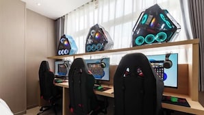 A hotel room with three gaming stations, each with a computer monitor, gaming chair, and a large, illuminated gaming PC tower. - Sangpin E-sports Hotel (Wenzhou Guoxi Branch) (Wenzhou)