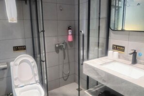 A modern bathroom with a glass-enclosed shower, a white toilet, and a marble sink. - Sangpin E-sports Hotel (Wenzhou Guoxi Branch) (Wenzhou)