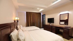 A hotel room with two beds, a desk, a television, and a mirror. - Hong Xin Business Hotel (Guangzhou)