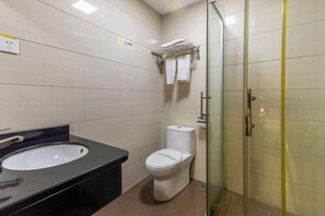 A bathroom with a black sink, white toilet, and a glass shower enclosure. - Hong Xin Business Hotel (Guangzhou)