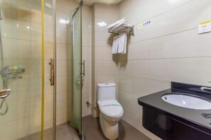 A bathroom with a glass shower enclosure, a white toilet, and a black sink. - Hong Xin Business Hotel (Guangzhou)