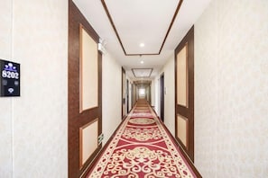 A hotel hallway with a red carpet, wooden paneling, and a sign indicating room number 8202. - Starlight Hotel(Jinggangshan Railway Station Store) (Jinggangshan City)
