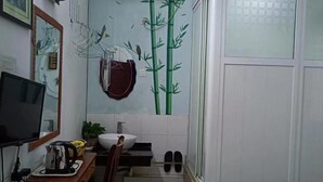 Un bagno con lavandino, specchio e televisore su un mobile in legno.